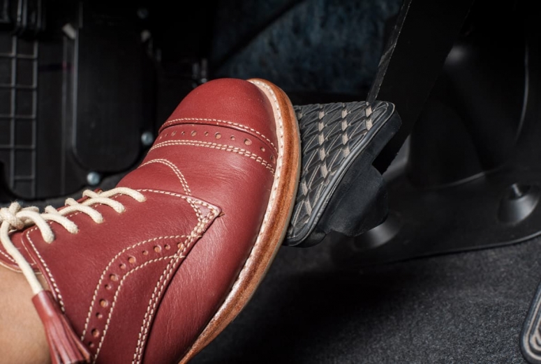 Why does the brake pedal sometimes feel stiff?